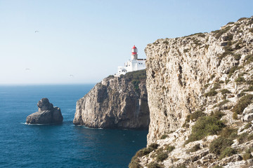 Fototapeta na wymiar High cliff over the sea with lighthouse on the top in Portugal.