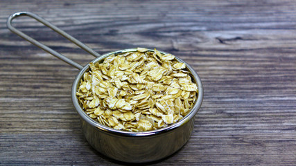 oatmeal close-up in the bowl. oatmeal or hercules flake close-up on a plate on wooden background. Healthy diet. Oatmeal porridge.