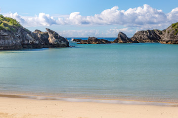 An idyllic Bermudan beach, with rock formations in the sea