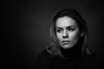 Dramatic black and white portrait of a beautiful woman on a dark background