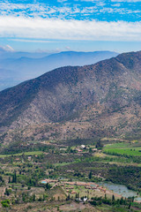 Obraz premium view of the valley between the mountains. view from above. to a residential valley. around the chilean mountains. below the village and ponds