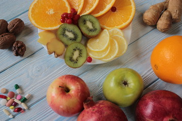 Naklejka na ściany i meble Fruit is on the plate , kiwi, oranges, lemon, pomegranate and tablets.