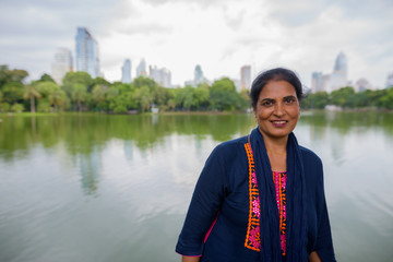 Mature beautiful Indian woman smiling in Lumpini park
