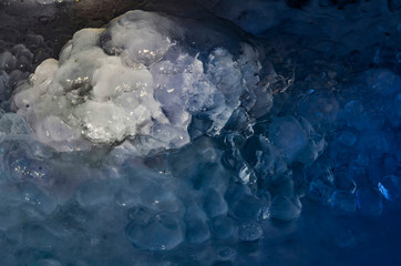 Close-up of frozen water turned into an ice floe with a beautiful multi-colored background