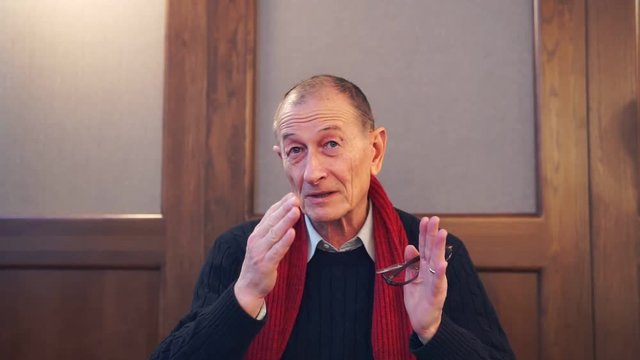 Businessman presentating business company. Senior man speaks to camera.