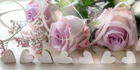 Reihe Holzherzchen mit Rosendekor im Hintergrund, Valentinskarte