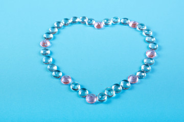 Heart of beads and pebbles on a blue background.