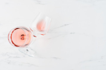 Summer drink. Glass of rose wine on white marble background with copy space for text. Top view....