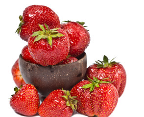 ripe berries of strawberry in a wooden bowl on a white background