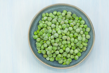 Frozen green peas in a bowl.