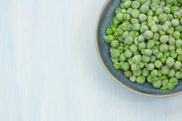 Frozen green peas in a bowl.
