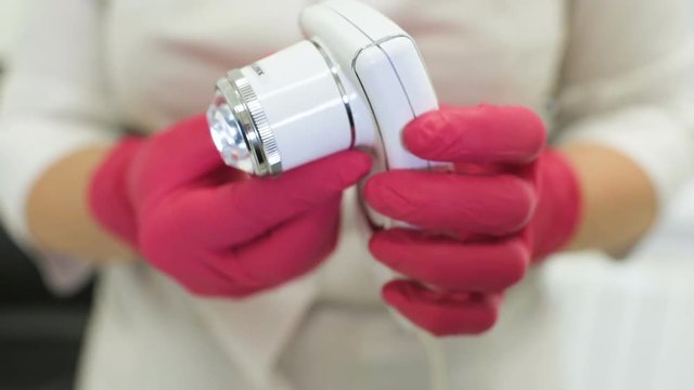 doctor dermatologist diagnoses hair structure using a special tool-a trichoscope. Trichology, trichogram