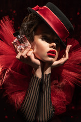 beautiful girl in a red heart costume holding a bottle of perfume