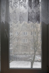 Winter window, drops of water and snowflakes on a window pane.