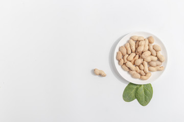 Peanuts on a white saucer. Top view.