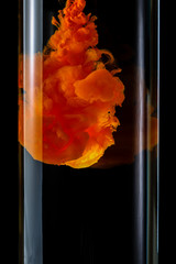 Acrylic paints dissolve in water on a black background. Abstract background.