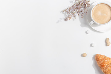 A cup of coffee with milk on a light background. Top view. Copy space.