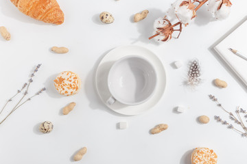 White empty cup on a light background. Composition with lavender, cotton and nuts.