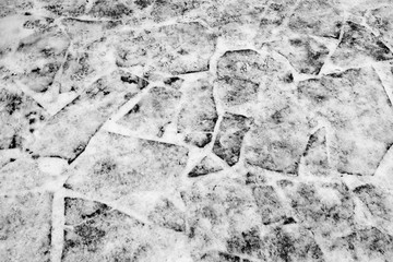 A fragment of a snow-covered road from a flat stone as the basis of the background.