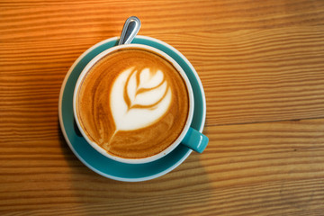 A cup latte art coffee on wood table