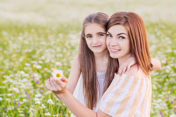 Mother and daughter in  field of daisies