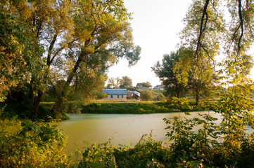 Light clouds in the warm summer sky over village with small light houses from brick far away in the forest. Small lake is near. Sunrise. morning.Travelling on the suburb roads