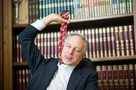 Businessman holding his necktie to hang himself