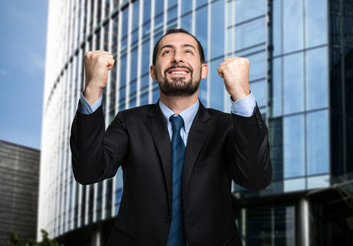 Happy businessman in front of his office