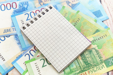 Russian money and notepad in a cage. Business still-life