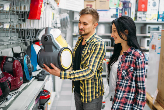 Couple choosing vacuum cleaner in supermarket