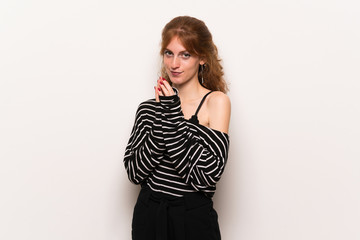 Young redhead woman over white wall scheming something