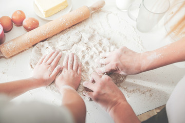 Hands Of Mother And Daughter Knead Dough For Pizza