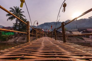 Bamboo bridge across small river with the sunshine