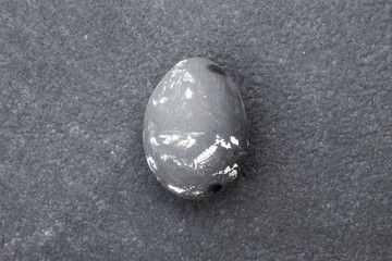 Egg painted in grey color on gray background