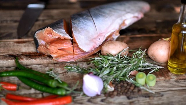 Fresh raw red fish with vegetables on the kitchen table
