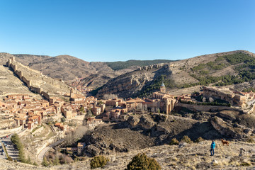  Hombre joven y su perro mirando un hermoso pueblo amurallado en España, llamado Albarracín.