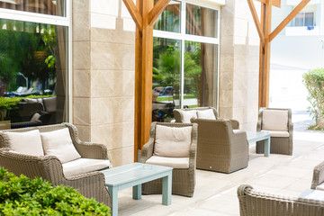 Lounge area for guests outside, rattan sofas and chairs around the table with flowers outside
