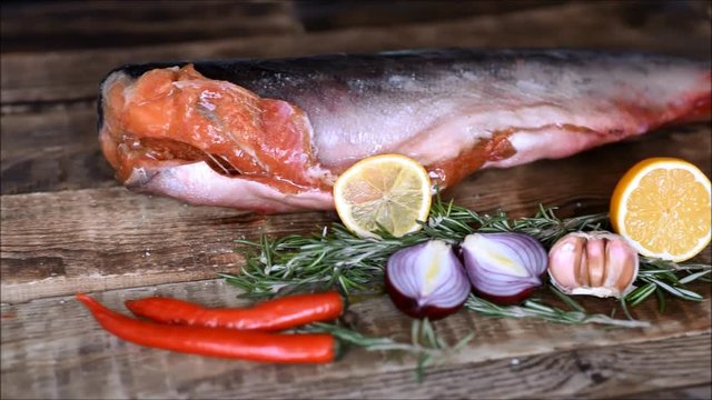 Fresh raw red fish with vegetables on the kitchen table
