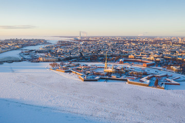 Beautiful aerial winter sunny view of Saint-Petersburg, Russia, Peter and Paul Fortress with cityscape and scenery beyond the city, shot from drone