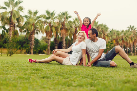 happy family playing and having fun near the palm trees