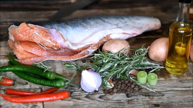 Fresh raw red fish with vegetables on the kitchen table
