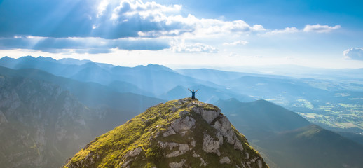 man on the top of a rock meeting sun