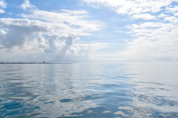 Minimalist blue sky and clouds over the ocean background