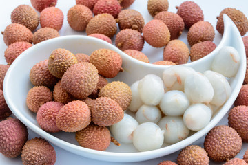 Lychee (LEE-chee; Litchi chinensis) is the sole member of the genus Litchi in the soapberry family, Sapindaceae.  Lychee is on a plate on a white background. Ripe lychee without shell.