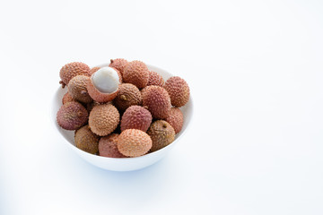 Lychee (LEE-chee; Litchi chinensis) is the sole member of the genus Litchi in the soapberry family, Sapindaceae.  Lychee is on a plate on a white background. Ripe lychee without shell. Tropical fruit.