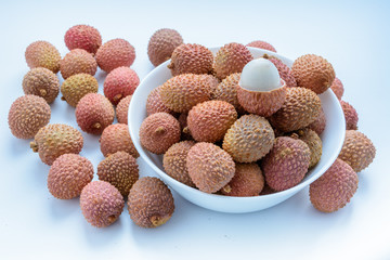 Lychee (LEE-chee; Litchi chinensis) is the sole member of the genus Litchi in the soapberry family, Sapindaceae.  Lychee is on a plate on a white background. Ripe lychee without shell. Tropical fruit.