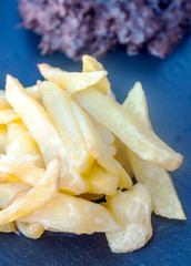 Beef steak with potatoes on black background