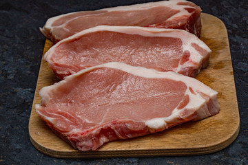 Pork loin chops on a wooden chopping board