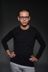 a man in a black jacket shows emotions in the Studio on a black background