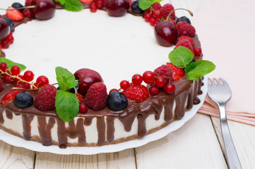 Delicious tart with fresh strawberries, raspberries and cherry on the table